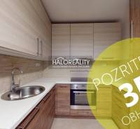 Küche in einer 2-Zimmer-Wohnung mit Holzboden und Einbauschränken.