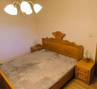 Schlafzimmer in einer 3-Zimmer-Wohnung mit Holzelementen und Nachttischen.