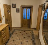 Flur in einer 3-Zimmer-Wohnung mit Spiegel, Fliesen und Holzmöbeln.