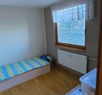 Gemütliches Zimmer in einer 3-Zimmer-Wohnung mit Bett und Holzboden.