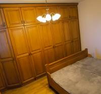 Schlafzimmer in einer 3-Zimmer-Wohnung mit einem großen Kleiderschrank und einem Bett.