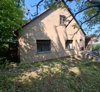 Ein Einfamilienhaus in der Búdková Straße in Bratislava - Altstadt, umgeben von Grün und einem Rasenstück.