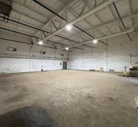 Ein Raum mit Betonboden und Beleuchtung, nutzbar als Büros in Poprad.