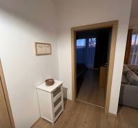 Innenraum einer 2-Zimmer-Wohnung mit Holzboden, hellem Möbeln und Dekorationen.