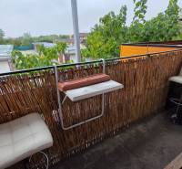 Balkon einer 3-Zimmer-Wohnung in Galanta mit modernem Geländer und weißen Barhockern.