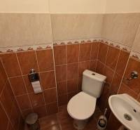 Toilette mit Bidet in einer 3-Zimmer-Wohnung, gefliest mit braunen und cremefarbenen Fliesen.