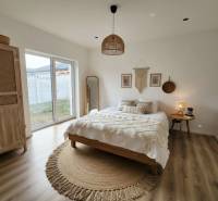 Schlafzimmer mit Bett, rundem Teppich, Kleiderschrank und Holzboden in einem Einfamilienhaus.