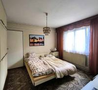 Schlafzimmer im Einfamilienhaus mit Bett, Schrank und Bild an der Wand.