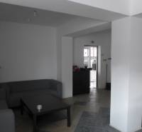 Wohnbereich mit grauen Sofas, Couchtisch und Fliesenboden in Lagerhäusern und Hallen.