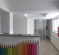 Innenraum von Lagern und Hallen mit einem Empfangstresen, der mit bunten Bleistiften und einem Feuerhydranten dekoriert ist.