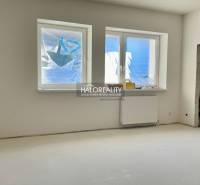 Ein Zimmer in einem Einfamilienhaus mit Fenstern und Heizkörper, ungenutzter Raum bereit zur Fertigstellung.