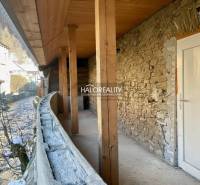 Ein Unterstand eines Einfamilienhauses in Hronec mit einer Steinmauer und einer Holzdecke.