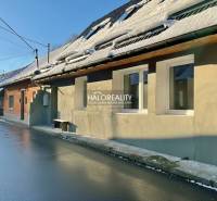 Ein Einfamilienhaus in Hronec mit schneebedecktem Dach und nasser Asphaltstraße.