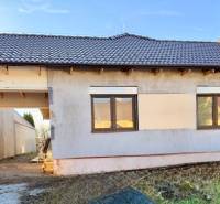 Ein Einfamilienhaus in Cífer mit einer unverputzten Fassade und einer braunen Dacheindeckung.