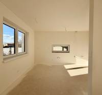 Innenraum eines Einfamilienhauses ohne Bodenbelag und mit Fenstern auf der Sonnenseite.