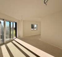 Geräumiges Zimmer mit großen Fenstern und Aussicht in einem Einfamilienhaus.