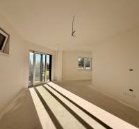 Ein geräumiges Zimmer in einem Einfamilienhaus mit großen Fenstern und Blick auf den Garten.