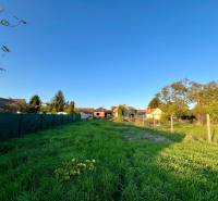 Grundstück mit Rasenbewuchs und Umzäunung in Cífer bei Einfamilienhäusern.