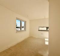 Ein leerer Raum mit Doppelfenster und Betonboden in einem Einfamilienhaus.