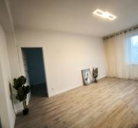 Ein Zimmer mit Vorhängen und einem Boden in Holzoptik in einer 4-Zimmer-Wohnung.