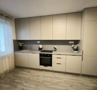 Küche in einer 4-Zimmer-Wohnung mit Holzboden und hellen Möbeln.