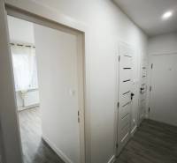 Der Flur in der 4-Zimmer-Wohnung mit weißen Türen und einem Boden in Holzoptik.