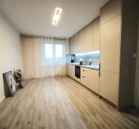 Küche in einer 4-Zimmer-Wohnung mit Holzboden und eingebauten Geräten.