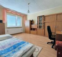 Schlafzimmer in einem Einfamilienhaus mit Holzboden, Möbeln und Bett.