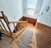 Eine Treppe mit einem Holzgeländer und Dekoration in einem Einfamilienhaus, Boden mit Holzdekor.