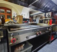 Küchen-Gastronomiebereiche mit Edelstahlausstattung und Dunstabzugshaube.