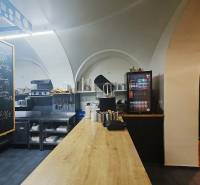 Innenraum eines Gastronomiebereichs mit Holzboden, Arbeitsplatte und Getränkekühlung.