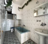 Badezimmer mit Badewanne, weißen Fliesen und grüner Dekoration in einer Wohnung mit 5 oder mehr Zimmern.