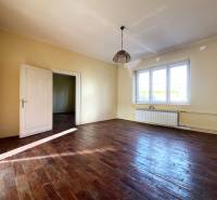 Ein Zimmer in einer 5- oder mehr-Zimmer-Wohnung mit einem Boden in Holzoptik und großen Fenstern.