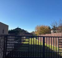 Das Grundstück in der Karpatská-Straße in Marianka ist von Grundstücken mit Wohnhäusern und grünem Rasen umgeben.