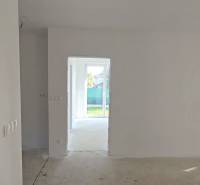 Ein Einfamilienhaus mit einem hellen Raum, weißen Wänden und großen Fenstern zum Garten.