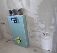 Unvollendetes Badezimmer in einem Einfamilienhaus mit vorbereiteter Installation in der Wand.