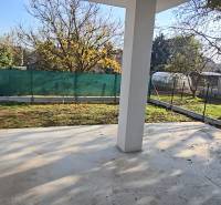 Ein Einfamilienhaus in Piešťany mit Garten, eingezäunter Hof mit Rasen und Bäumen auf dem Grundstück.