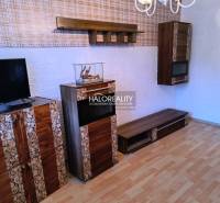 Wohnzimmer in einer 3-Zimmer-Wohnung mit Fernseher und Holzboden.