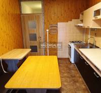 Küche in einer 3-Zimmer-Wohnung mit Holzboden, Tisch und eingebauter Bank.