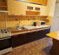 Küche in einer 3-Zimmer-Wohnung mit einem Gasherd und einem Boden in Holzoptik.