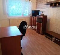 Ein Zimmer mit einem Holzboden, einem Büroschreibtisch und Regalen in einer 3-Zimmer-Wohnung.