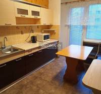 Küche in einer 3-Zimmer-Wohnung mit hellen Schränken, einer Eckbank und einem Boden mit Holzdekor.