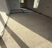 Innenraum eines Einfamilienhauses mit Betonboden und großen Fenstern in Most pri Bratislave.