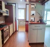 Küche in einem Studio-Apartment mit Holzboden und hellem Interieur.