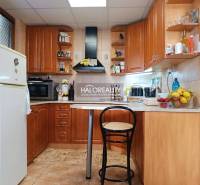 Eine Küche in einer Hütte mit Holzeinrichtung, Bartresen und Geräten.