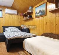 Ein Zimmer in einer Hütte mit Holzwandverkleidung und einem bequemen Bett.