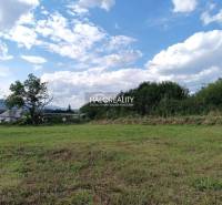 Grundstücke - Wohnen in Čerhov, Grasfläche, Bäume, entfernte Häuser, Hügel, blauer Himmel.