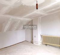 Ein Interieur mit weißer Decke, Heizkörper und Boden in einem Einfamilienhaus.