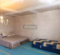 Ein Schlafzimmer in einem Einfamilienhaus mit Bett, Matratze, Leuchte und einfacher Möbel.