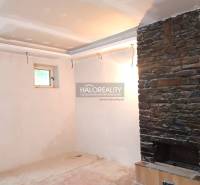 Interieur eines Einfamilienhauses mit einem Steinkamin und einem kleinen Fenster.